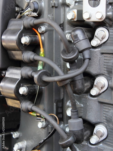 High-voltage wires with tips and ignition coils close-up on a four-cylinder outboard motor - petrol engine ignition system