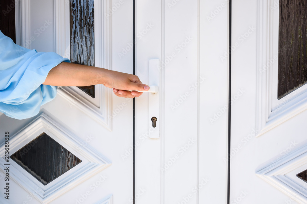 front door. hand holds doorknob on front door PVC front door. hand holds doorknob on front door PVC