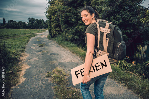 junge Tramperin mit Pappschild Ferien photo