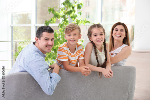 Happy family with cute children on sofa at home