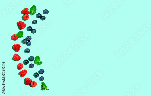Blueberries and raspberries on a solid color background