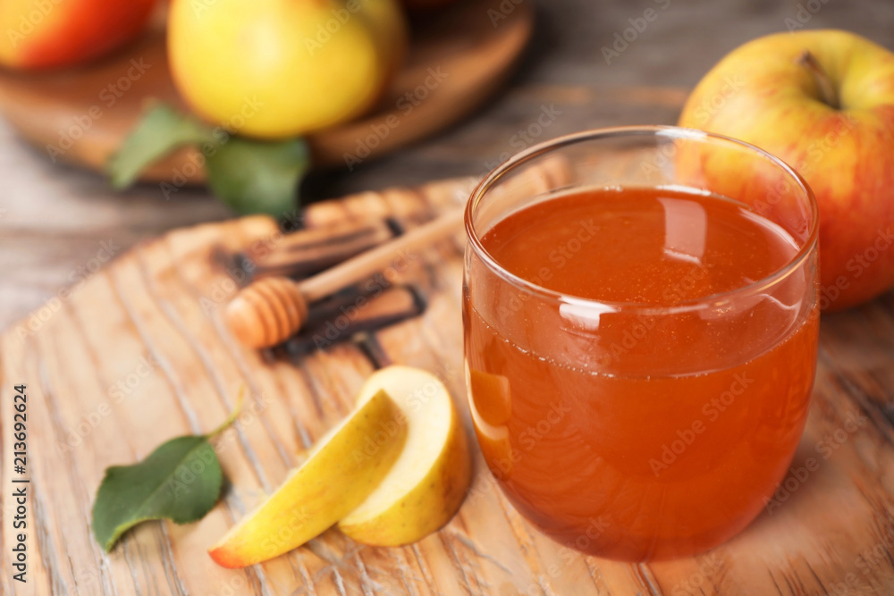 Glass of honey and apples on wooden board Glass of honey and apples on wooden board