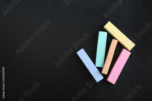 Color pieces of chalk on blackboard  top view