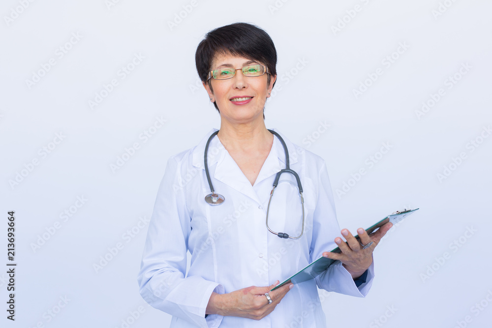 Portrait Of Female Doctor Writing On Clipboard Over a white background Portrait Of Female Doctor Writing On Clipboard Over a white background