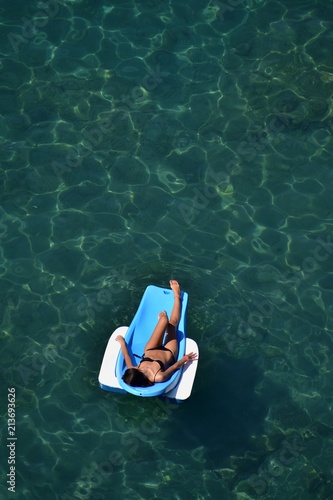 Donna prende il sole sul lettino galleggiante