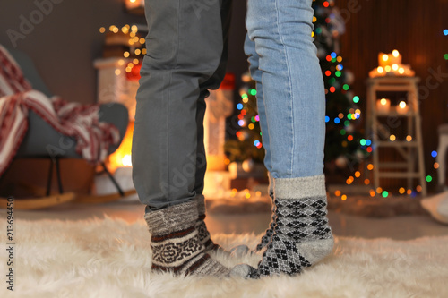 Young couple in warm socks celebrating Christmas at home