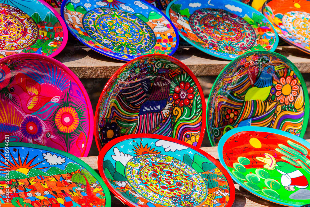 Souvenirs on the market at Chichen Itza. Maya Indians plates. Beautiful bright dishes, plates. Colorful Cookware Souvenirs on the market at Chichen Itza. Maya Indians plates. Beautiful bright dishes, plates. Colorful Cookware