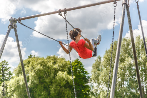 View of a girl rising high on a swing in a park