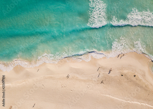 Top view of beautiful beach. Aerial drone shot of turquoise sea water at the beach - space for text. Caribbean seaside beach with turquoise water and big waves aerial view. Cancun beach aerial view. 