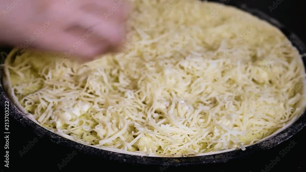 women's hands sprinkle with cheese round pizza women's hands sprinkle with cheese round pizza