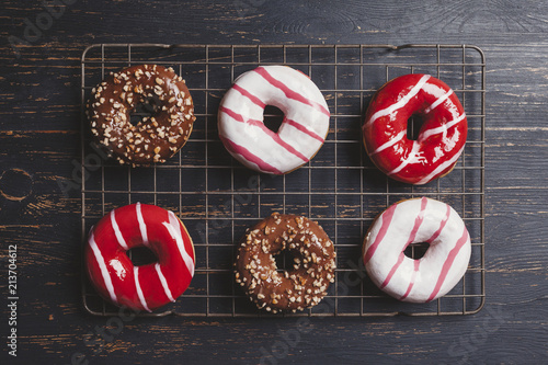 Overhead view of colorful donuts on cooling rack