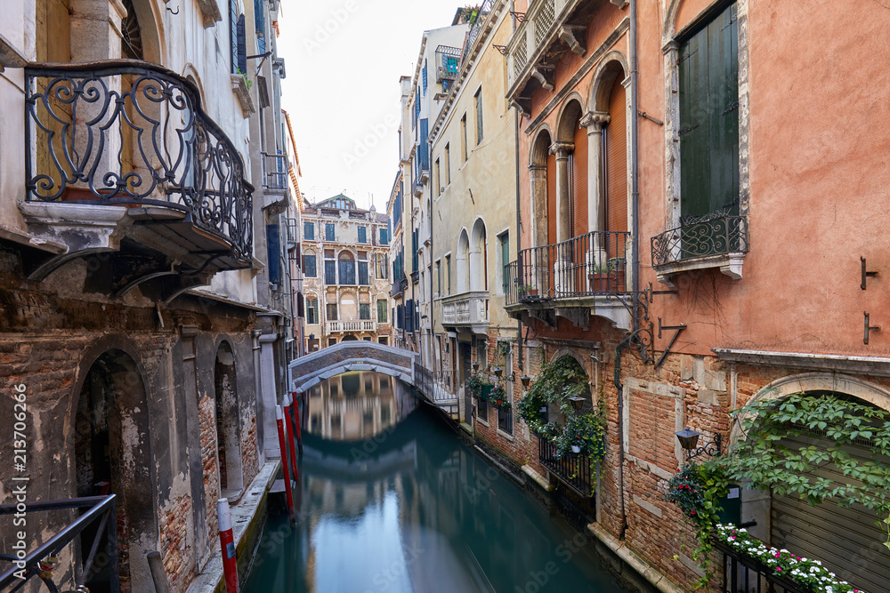 Venice canal with ancient buildings and houses facades in Italy