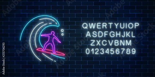 Glowing neon sign of surfer in ocean wave with alphabet. Man on surfboard on waves. Symbol of summer leisure