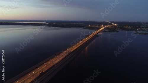 Wallpaper Mural Amazing aerial view of bridge and city when sun goes down, beautiful panorama of small city with traffic moving on road, calm river under clear blue sky on late evening in summer. Concept Torontodigital.ca