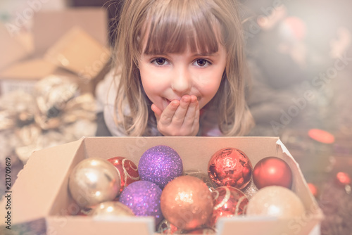Cute girl and a box of Christmas decorations