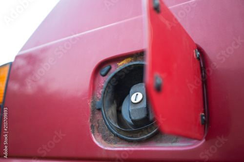 open fuel tank of a red passenger car