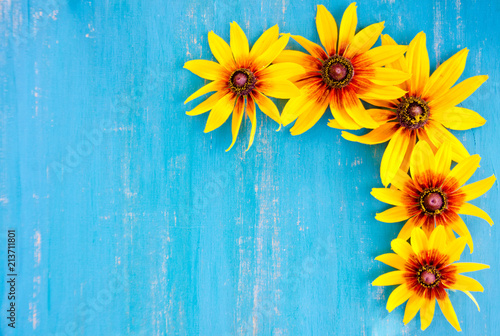 Fototapeta Naklejka Na Ścianę i Meble -  yellow flowers on a bright blue wooden background