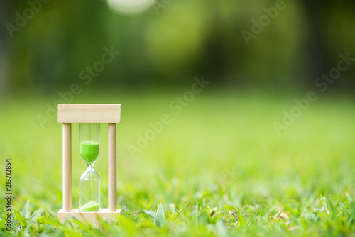 hourglass on green grass field , spring time