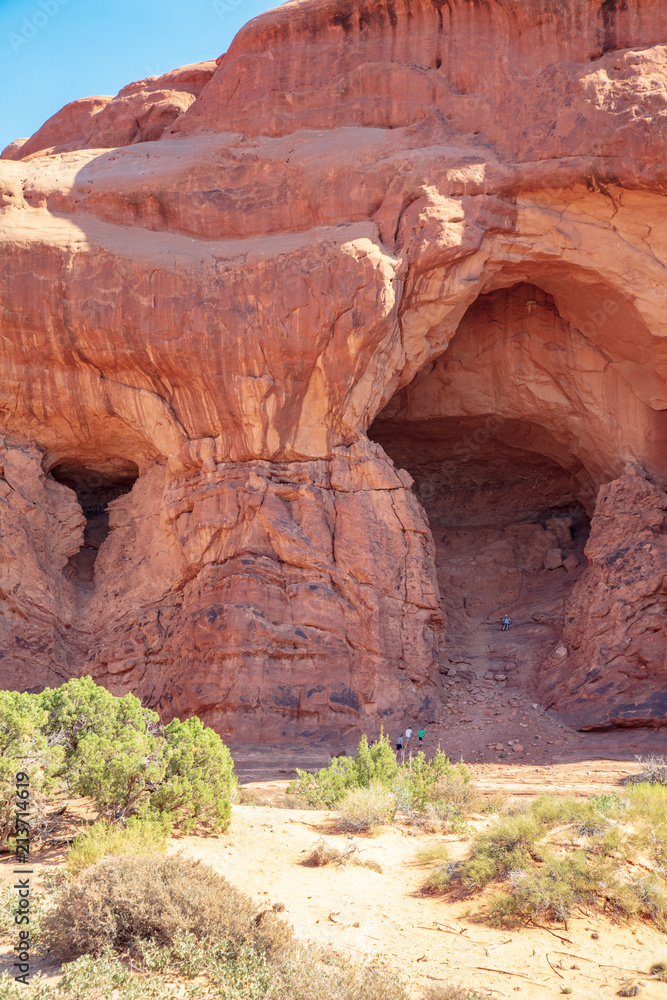 The start of a new arch within the Double Arch formation along The Windows Trail in Arches National Park with rock climbers