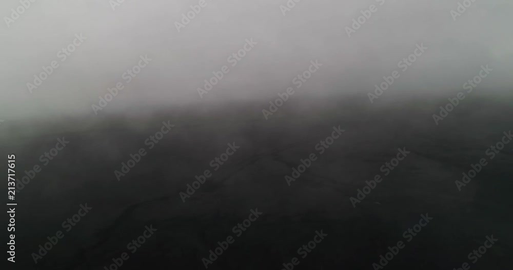 aerial shot through fog and clouds with black sand in iceland aerial shot through fog and clouds with black sand in iceland