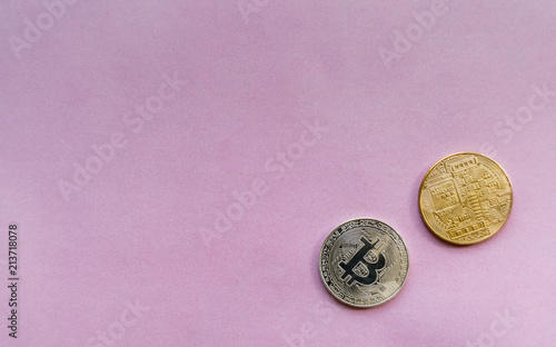Coins are silver and golden bitcoin lies on a pink background and there is a place for the header