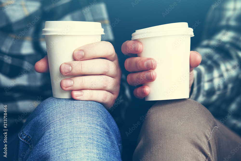 Couple in plaid shirts with two white paper cups of morning coffee Couple in plaid shirts with two white paper cups of morning coffee