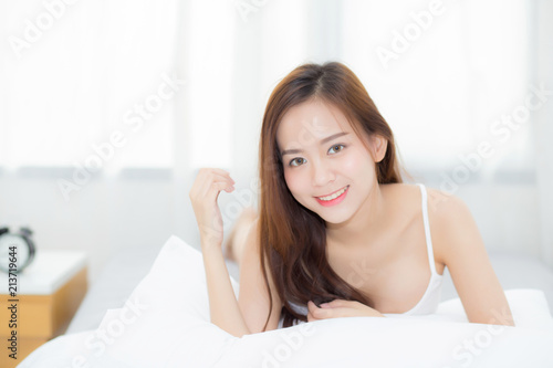 Beautiful portrait young asian woman lying and smile while wake up with sunrise at morning  lifestyle and relax concept.