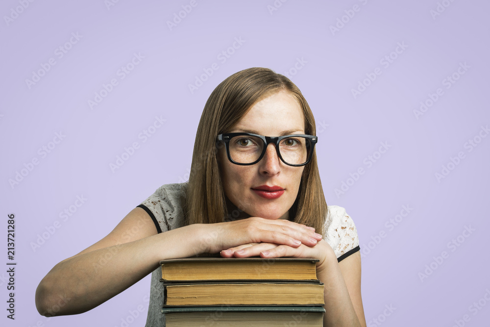 A young girl in a white dress and glasses put her hands on a pil A young girl in a white dress and glasses put her hands on a pil