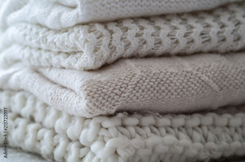 Background with warm sweaters. Pile of knitted clothes in warm shades, space for text, Autumn winter concept. Copy Space.
