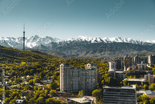 City landscape on a background of snow-capped Tian Shan mountains in Almaty Kazakhstan photo