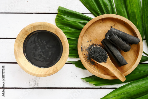 Facial mask and scrub by activated charcoal powder on wooden table