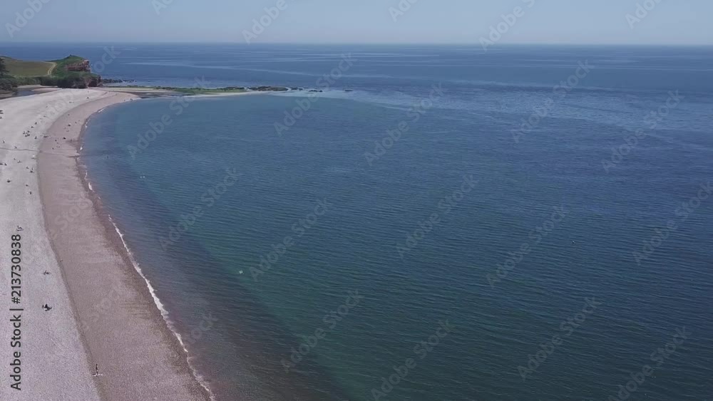Flying out towards the curved seashore in Devon, UK, AERIAL STATIC CROP Flying out towards the curved seashore in Devon, UK, AERIAL STATIC CROP