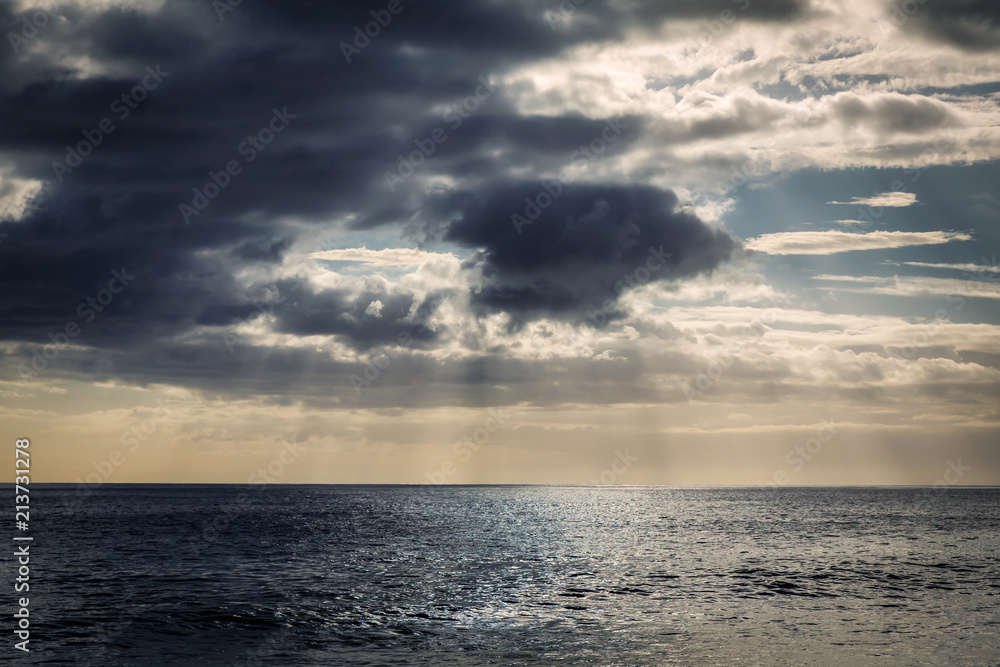 Evening view with sun shining throug clouds at Makua beach, Oahu, Hawaii