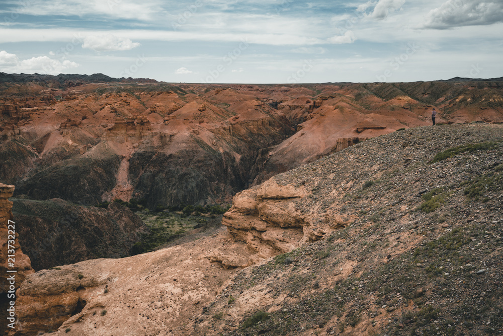 Charyn Grand Canyon with clouds and sun red orange stone Martian landscape Charyn Grand Canyon with clouds and sun red orange stone Martian landscape