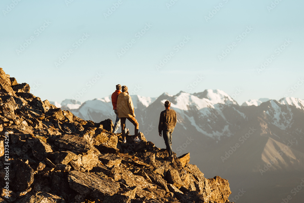 Fototapeta premium Happy friends having fun at sunset time in mountains range backdrop. Space for text