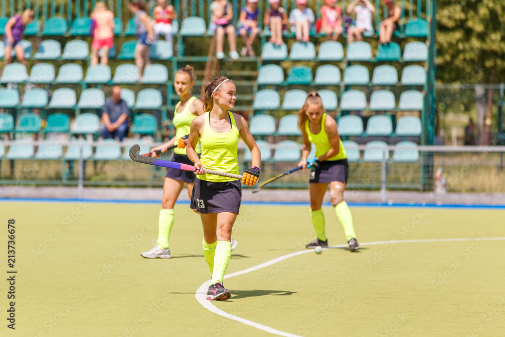 Young field hockey player girl with stick in the game Young field hockey player girl with stick in the game