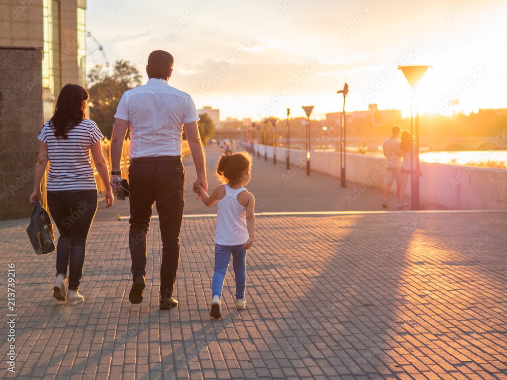 Fototapeta premium Happy family walks in the evening light