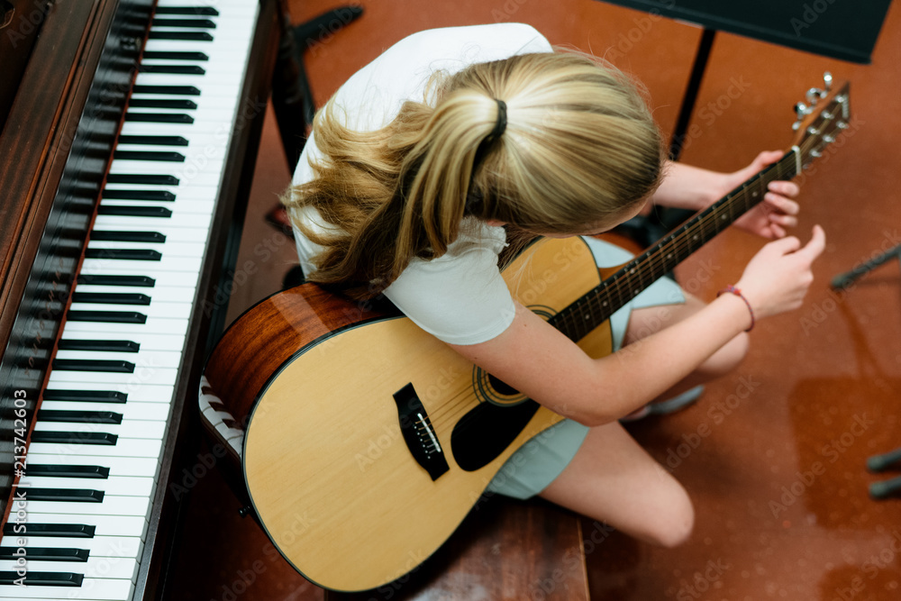 music student practices guitar in practice room
