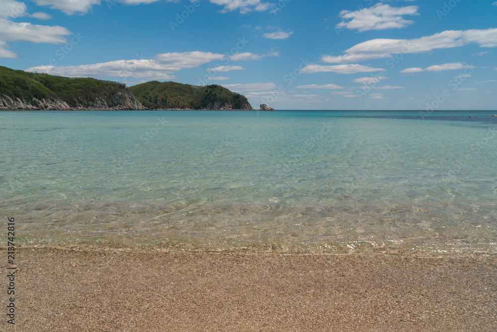 Beautiful blue water bay, empty beach, crystal clean water, blue sky on sunny day