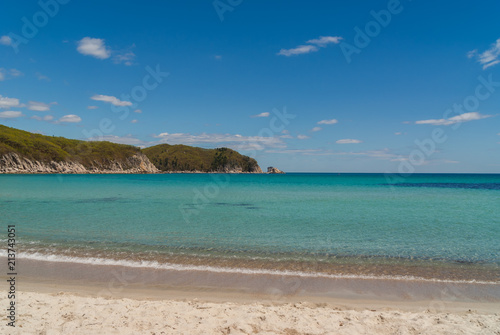 Beautiful blue water bay, empty beach, crystal clean water, blue sky on sunny day