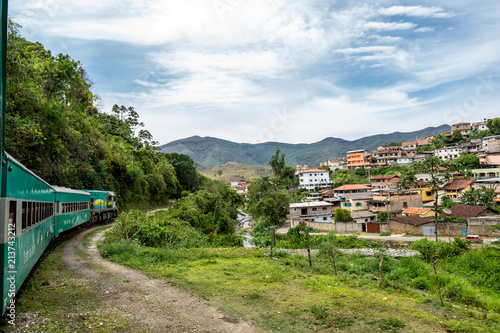 Steam train to Ouro Preto passing a village on a hill