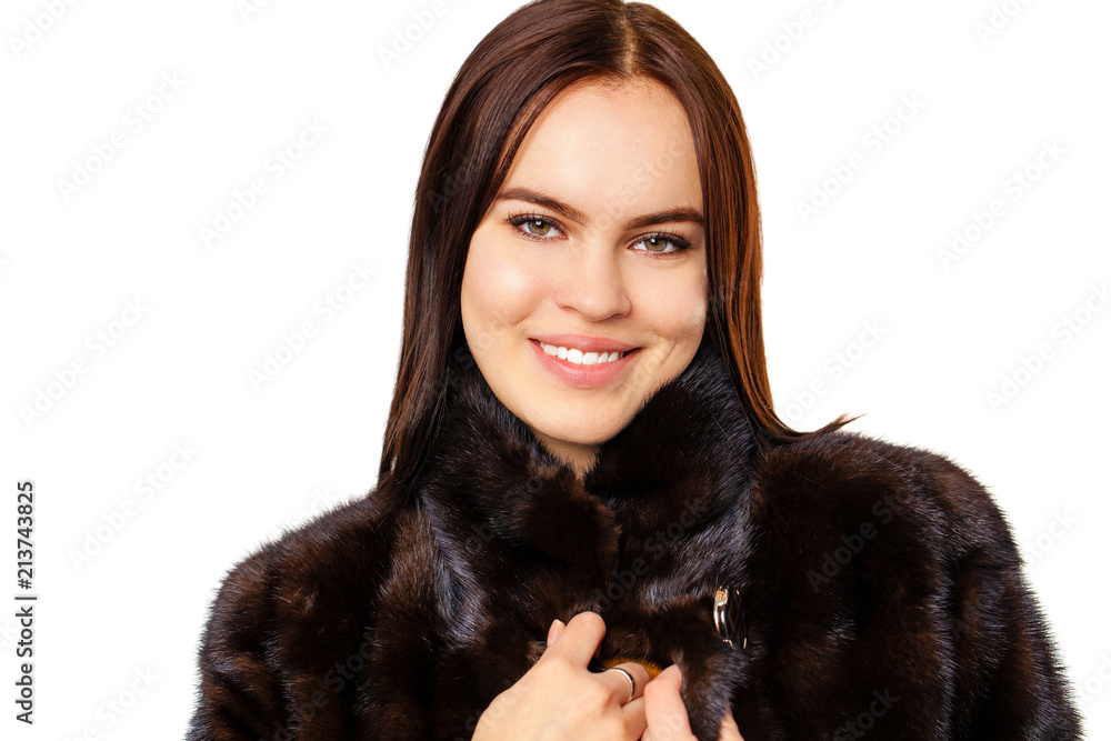 Young beautiful brunette woman in fur mink coat posing on white isolated Young beautiful brunette woman in fur mink coat posing on white isolated