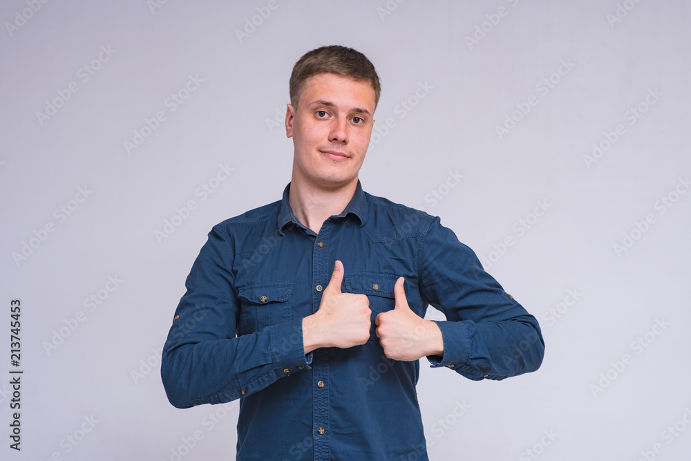 portrait of a young handsome man on a white background in a shirt showing different emotions of happiness and surprise. portrait of a young handsome man on a white background in a shirt showing different emotions of happiness and surprise.