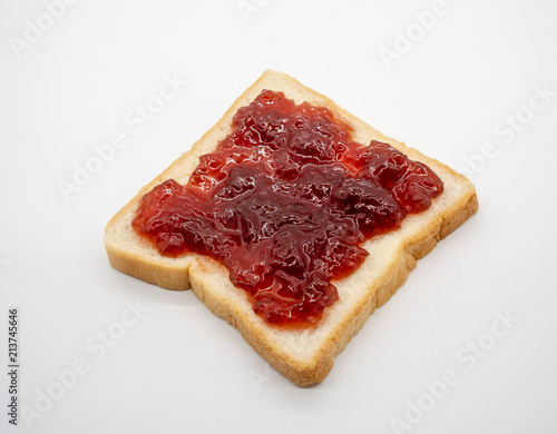 homemade slide bread with strawberry jam isolated on white