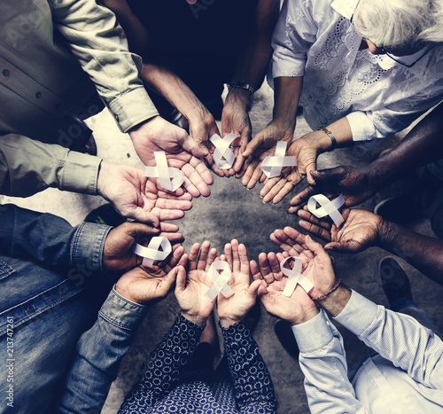 Aerial view of white ribbons on people palms for bone cancer awareness and antiviolence photo