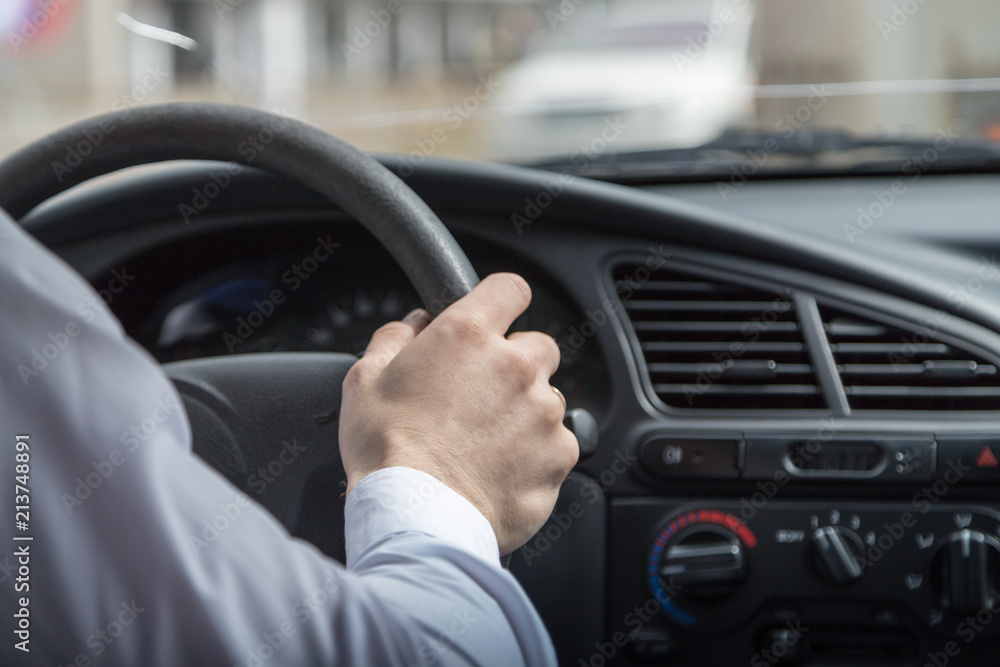 Man hands holding steering wheel while driving car