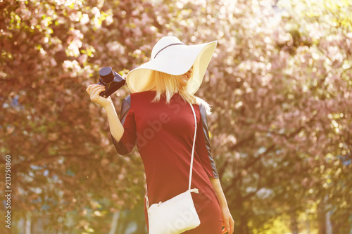 Beautiful girl in summer hat holding camera