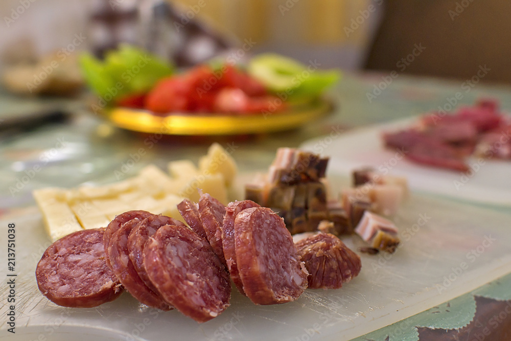 Serbian breakfast with sliced domestic sausage, bacon, ham and cheese.
