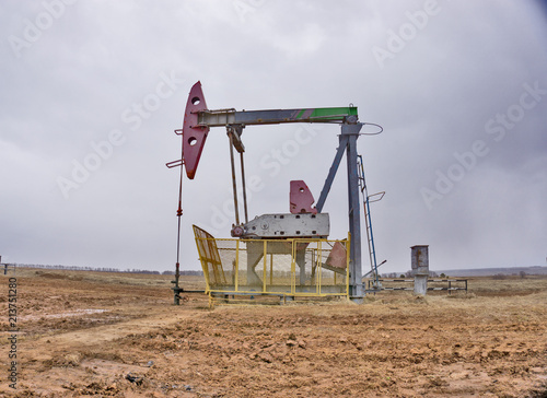 The beam pumping unit is homework, sunset in oil field. Oil pump oil rig energy industrial machine for petroleum. The pumping unit as the pump installed on a well. Equipment of oil fields. © sudya