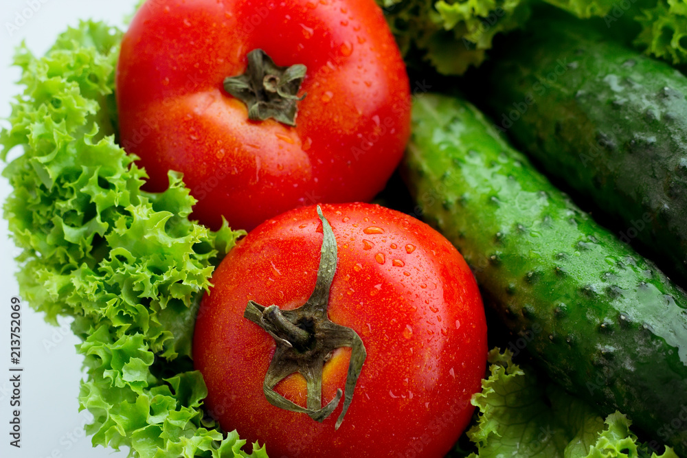 Fresh red tomatoes, green salad and cucumber Fresh red tomatoes, green salad and cucumber